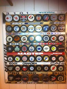 a large display of various types of hockey pucks on a wall in a room