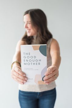 a woman holding up a book with the words, the good enough mother on it