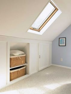 an attic bedroom with skylight and storage baskets in the closet area on the far wall