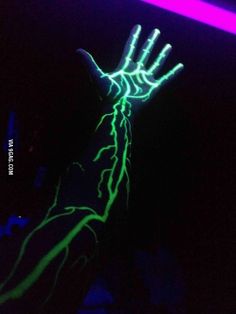 a person holding their hand up in the air with neon lights on it's fingers