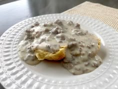 a white plate topped with biscuits and gravy