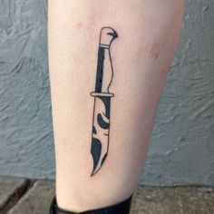 a knife tattoo on the leg of a person's leg with a black and white design