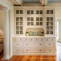 a kitchen with white cabinets and wooden floors