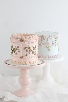 two cakes sitting on top of a white cake stand next to each other in different colors