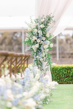 an outdoor ceremony setup with white and blue flowers