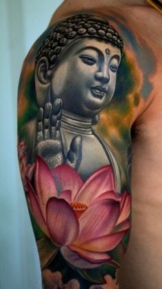 a man's arm with a buddha tattoo on it and a lotus flower in the foreground