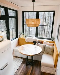 a kitchen with a table, couch and windows