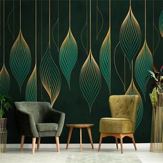 two chairs and a table in front of a green wall with gold leaves on it