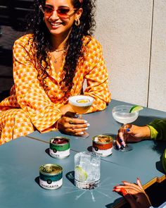 two women sitting at a table with food and drinks