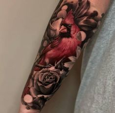 a man with a red bird and flowers on his arm