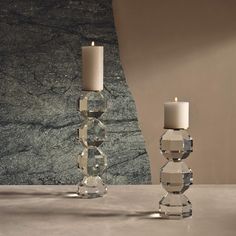 two crystal candles sitting next to each other on a table