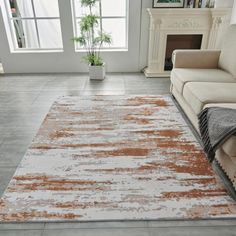 an orange and white rug in a living room with a couch, chair, fireplace and potted plant