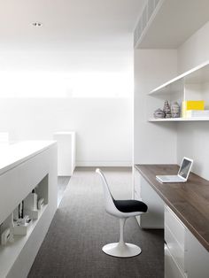 a modern office with white walls and shelving