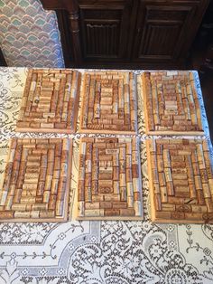 four wooden coasters sitting on top of a white and blue patterned table cloth next to a dresser