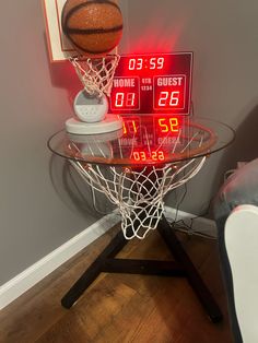 a glass table topped with a basketball next to a clock on top of a wooden floor