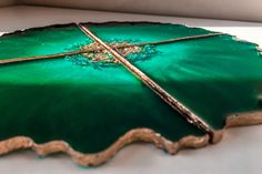 a green plate with gold trim and cross on it sitting on a white counter top