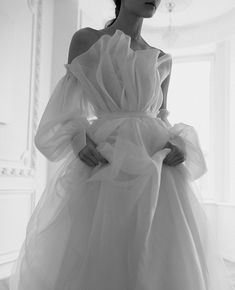 a woman in a white dress is posing for the camera with her hands on her hips