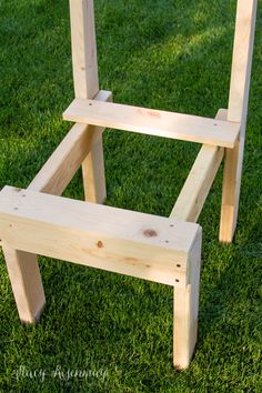 a wooden chair sitting on top of green grass