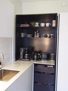 the kitchen is clean and ready to be used as a storage unit for coffee or tea