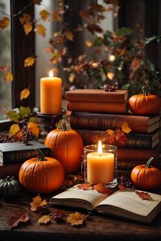 pumpkins, books and candles on a table