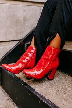 Keep your look chic with our red 'Yasmine' bootie featuring sleek patent material, a rounded closed toe, a 4-inch block heel, an inside ankle zip closure, and an above-the-ankle silhouette! This patent bootie runs more true to size.