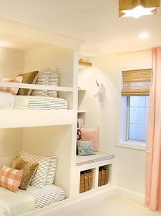 a bedroom with bunk beds and pillows on top of them in front of a window