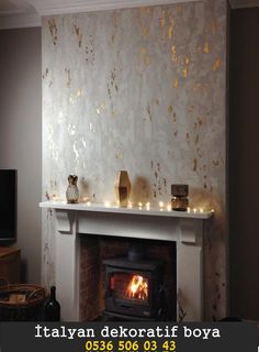 a living room with a fire place next to a tv on a wall and candles in front of the fireplace