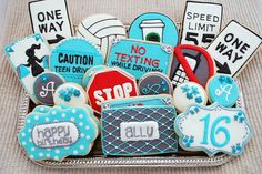 decorated cookies are arranged in a basket on a tableclothed surface with signs and other items