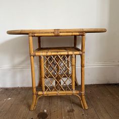 a small table made out of bamboo with a wine rack on it's side