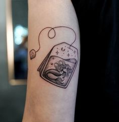 a woman's arm with a tattoo on it and an image of a fish in a jar