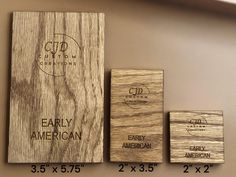 three wooden business cards are on display next to each other, with the same logo