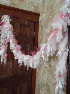 pink and white streamers hanging from the side of a door