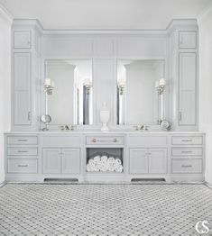 a white bathroom with two sinks and mirrors