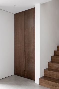 an empty room with wooden stairs and white walls