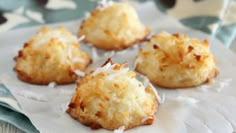 four coconut cookies sitting on top of a piece of paper