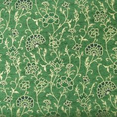 a green and white floral pattern on a plain material background that looks like woolen fabric