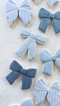 decorated cookies with blue and white bows on top of a table next to each other