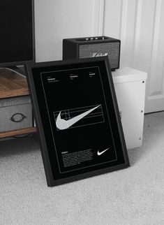 a black and white photo of a nike advertisement on the floor next to an amplifier