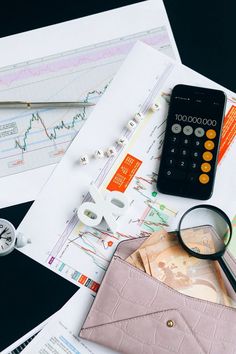 a calculator, magnifying glass, money and other items on a table