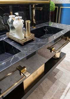 two black sinks with gold accents in a bathroom area that looks like it has been designed to look like an art deco