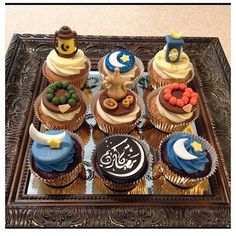 there are many cupcakes on the tray and one is decorated with arabic writing