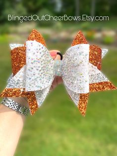 Listing is for 1 cheer bow, Orange , white and silver with rhinestone detail.  Bow is 7" wide, fit for cheer competition.  This is a showstopper bow, you will sparkle from the stage! orange and black cheer bow.   #custom cheer bows #cheer bow team orders like us on facebook "blinged out cheer bows" Cheer Competition, Custom Cheer Bows, Cheer Bows, Leather Bows, Etsy App