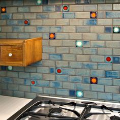 a stove top oven sitting next to a wall covered in blue and red tile tiles