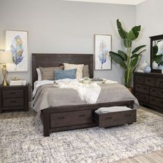 a bedroom with a bed, dressers and mirror on the wall next to it