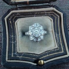 an antique diamond ring sits in its velvet case