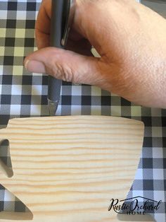 a person is using a knife to cut up a piece of wood on a table