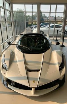 a white sports car is parked in a showroom