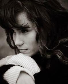 black and white photograph of a woman with long hair wearing a sweater looking at the camera