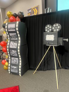 a black and white movie projector sitting on top of a tripod in front of a stage