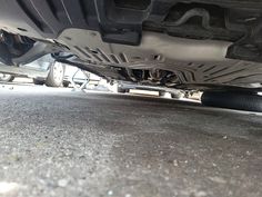 the front end of a car with it's exhaust pipe exposed to the ground